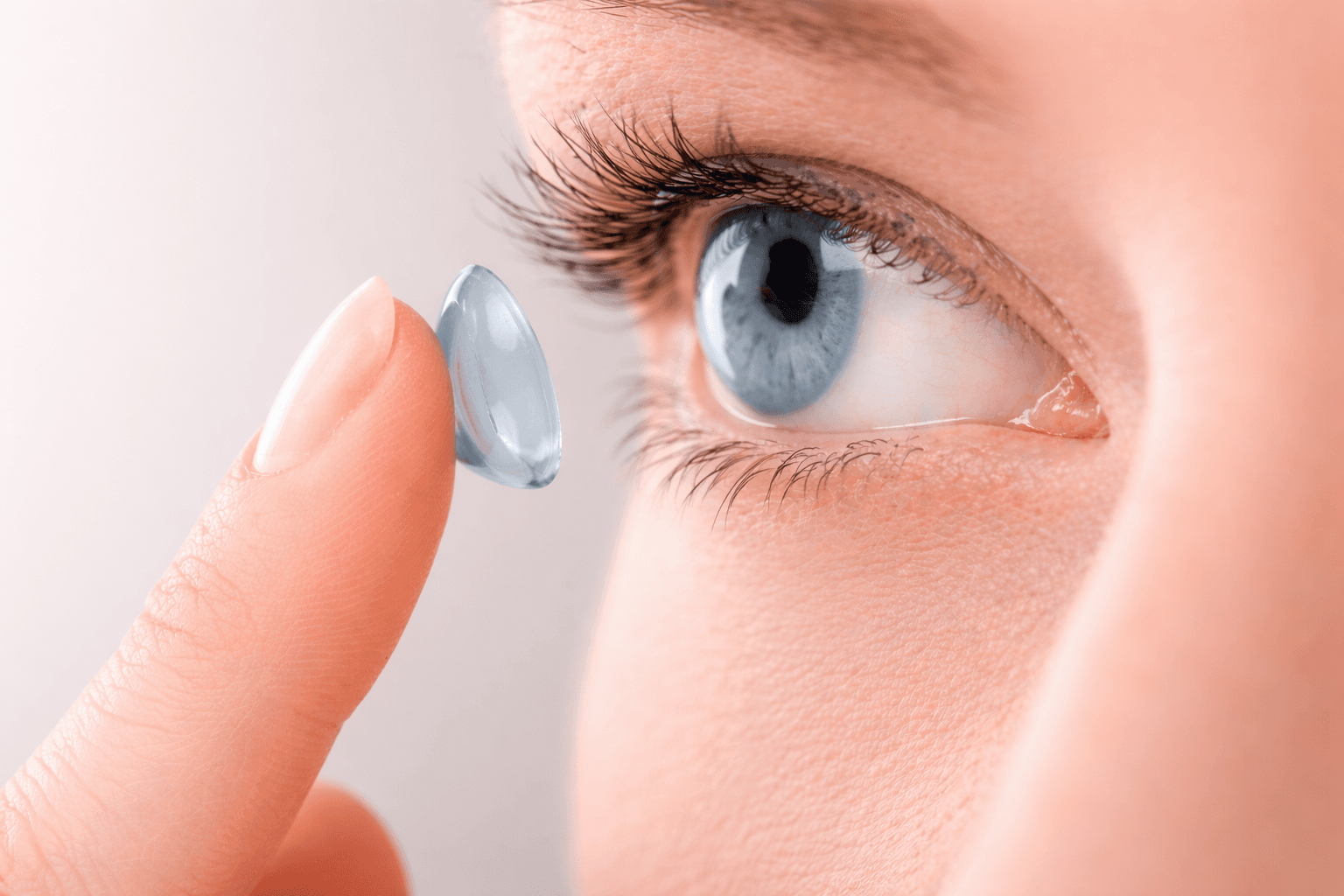 Kontaktlinse auf Finger vor Auge